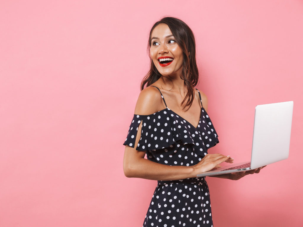 Woman smiling while holding her laptop